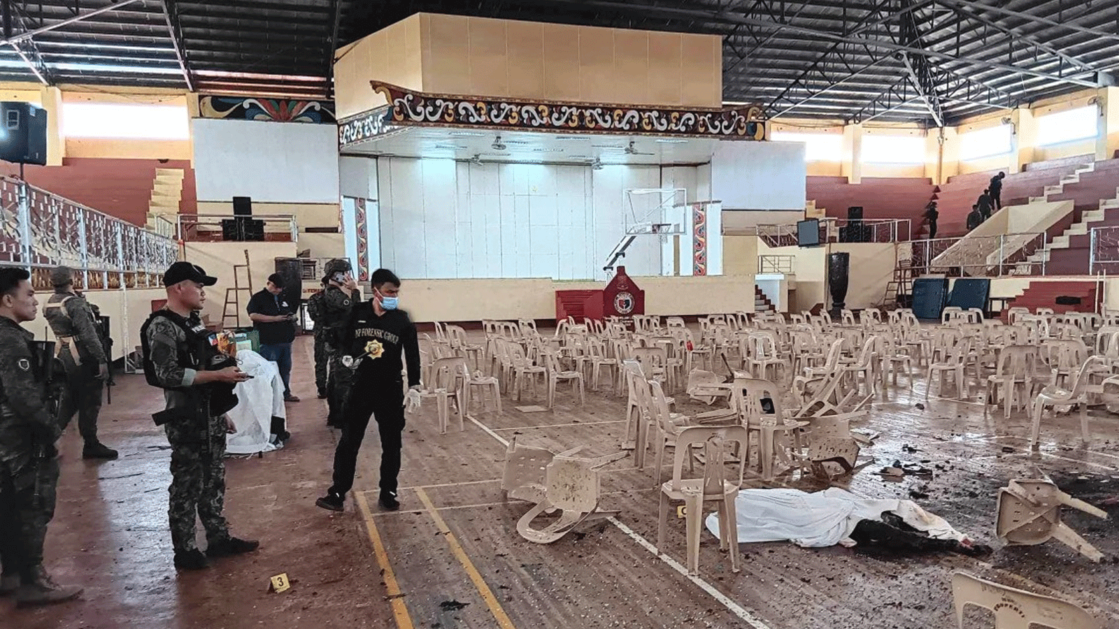 أفراد عسكريون يقفون للحراسة عند مدخل صالة للألعاب الرياضية بينما يبحث محققو الشرطة عن أدلة بعد هجوم بالقنابل أدى إلى مقتل أربعة أشخاص على الأقل في الفلبين يوم أمس الأحد 3 ديسمبر(كانون الاول) 2023