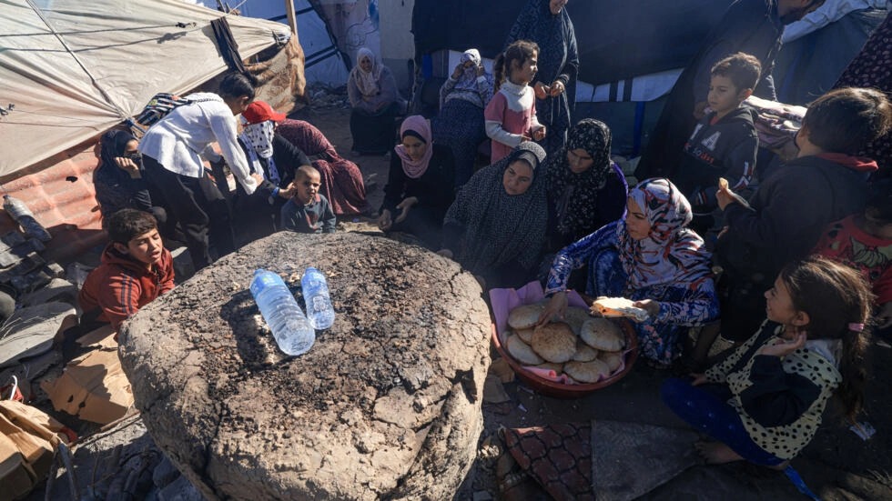 نازحون فلسطينيون يخبزون في دير البلح في قطاع غزة بتاريخ 30 نوفمبر 2023
