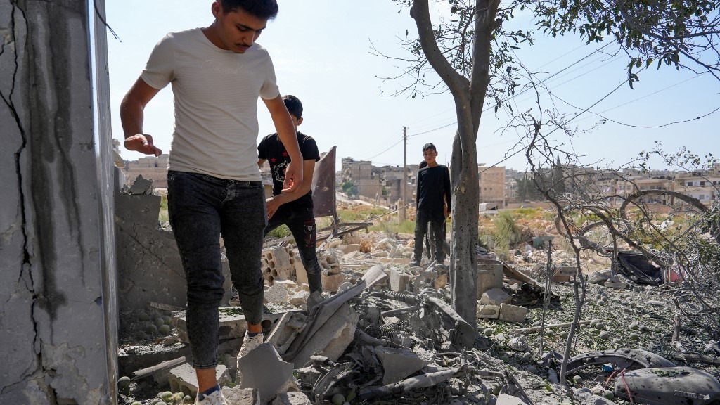 سوريون يتفقدون الأضرار التي لحقت بمنزل في مدينة إدلب شمال غربي سوريا إثر قصف قوات النظام السوري، 6 أكتوبر 2023