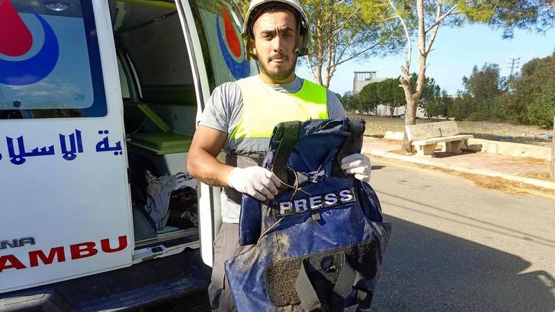 أحد عناصر الدفاع المدني اللبناني يحمل سترة صحفية مضادة للرصاص قيل إنها كانت لأحد الصحفيين الذين قتلوا في غارة إسرائيلية في جنوب لبنان