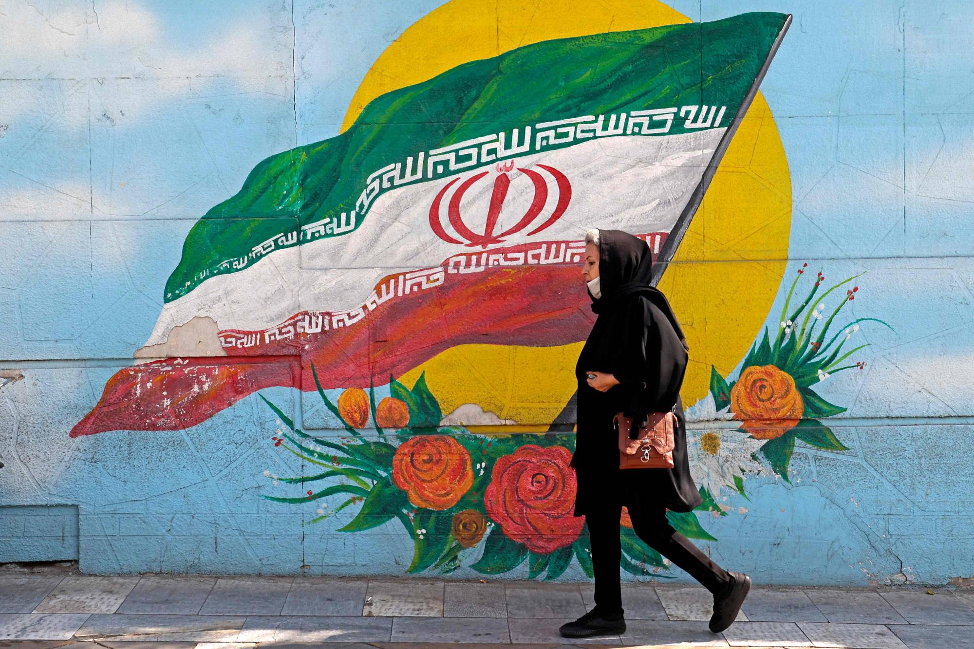 امرأة تسير في أحد شوارع طهران