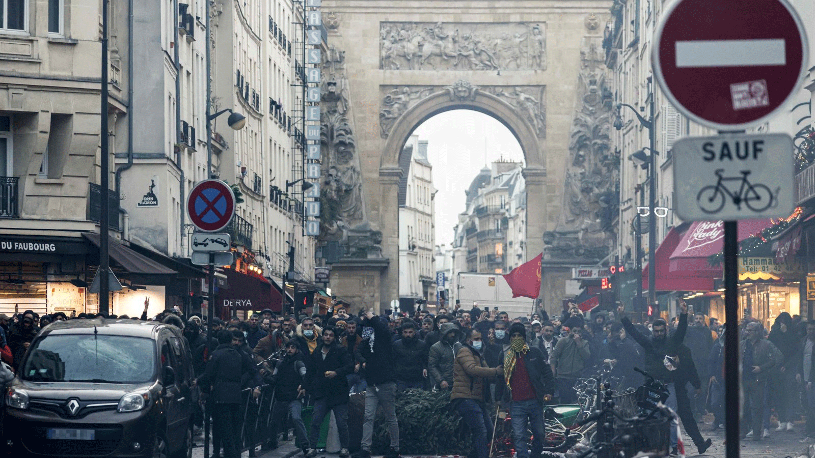 متظاهرون يقفون أمام ضباط شرطة مكافحة الشغب بعد تصريح لوزير الداخلية الفرنسي جيرالد دارمانين (غير مرئي) في الموقع الذي أطلقت فيه عدة طلقات على طول شارع دينجين في الدائرة العاشرة، في باريس في 23 ديسمبر(كانون الأول) 2022