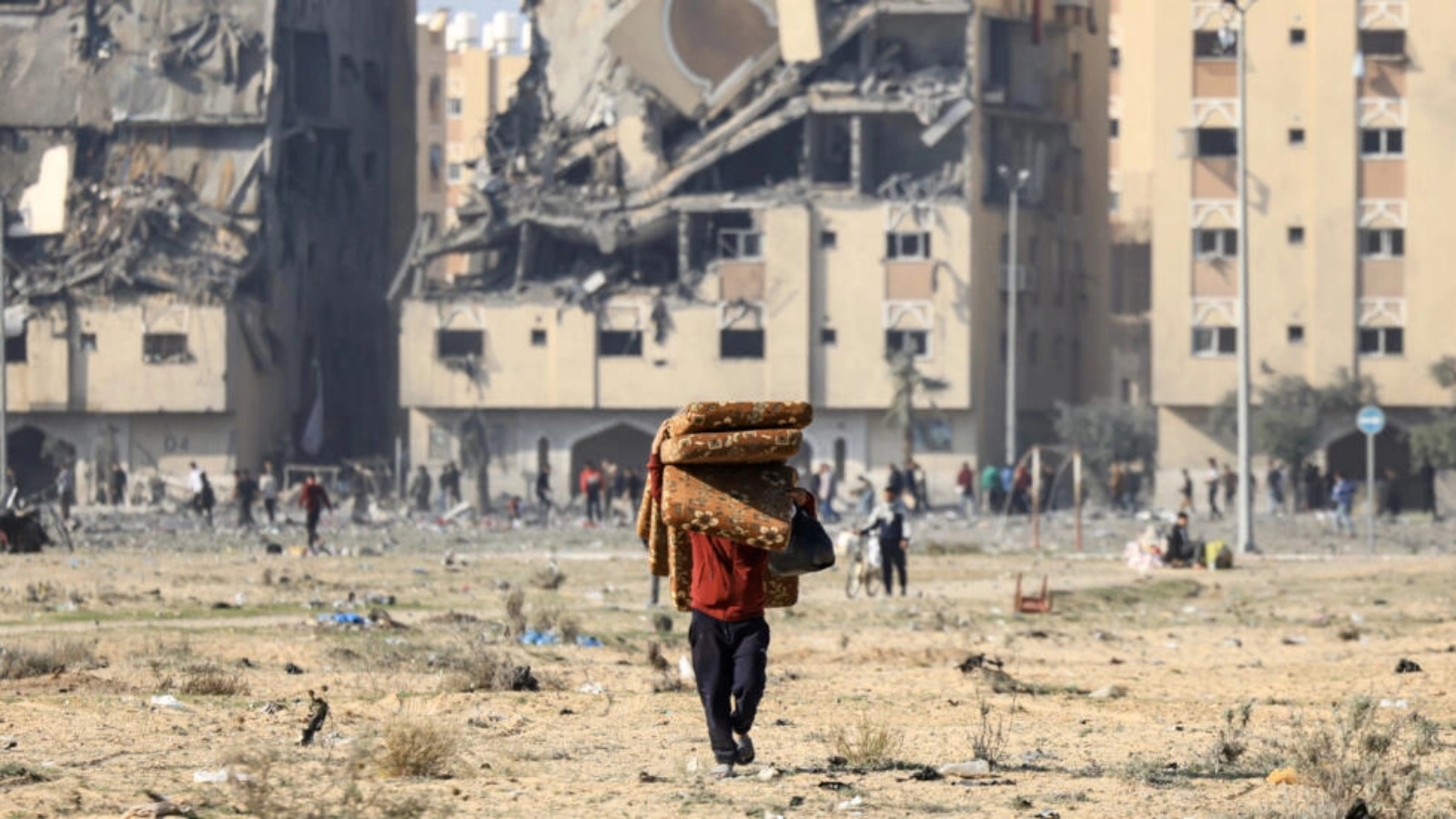 سكان في مدينة حمد السكنية في خان يونس بقطاع غزة يحملون حاجياتهم بعد قصف إسرائيلي في الثاني من ديسمبر 2023 