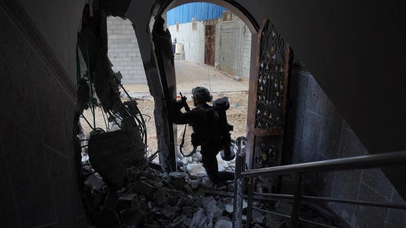 جندي إسرائيلي يقف داخل مبنى تعرض للقصف شمال قطاع غزة