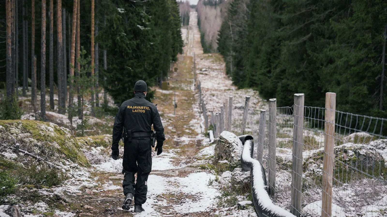 ضابط كبير في حرس الحدود يوهو بيلينين يسير على طول السياج الذي يحدد المنطقة الحدودية بين فنلندا وروسيا بالقرب من معبر بيلكولا الحدودي في إيماترا بفنلندا