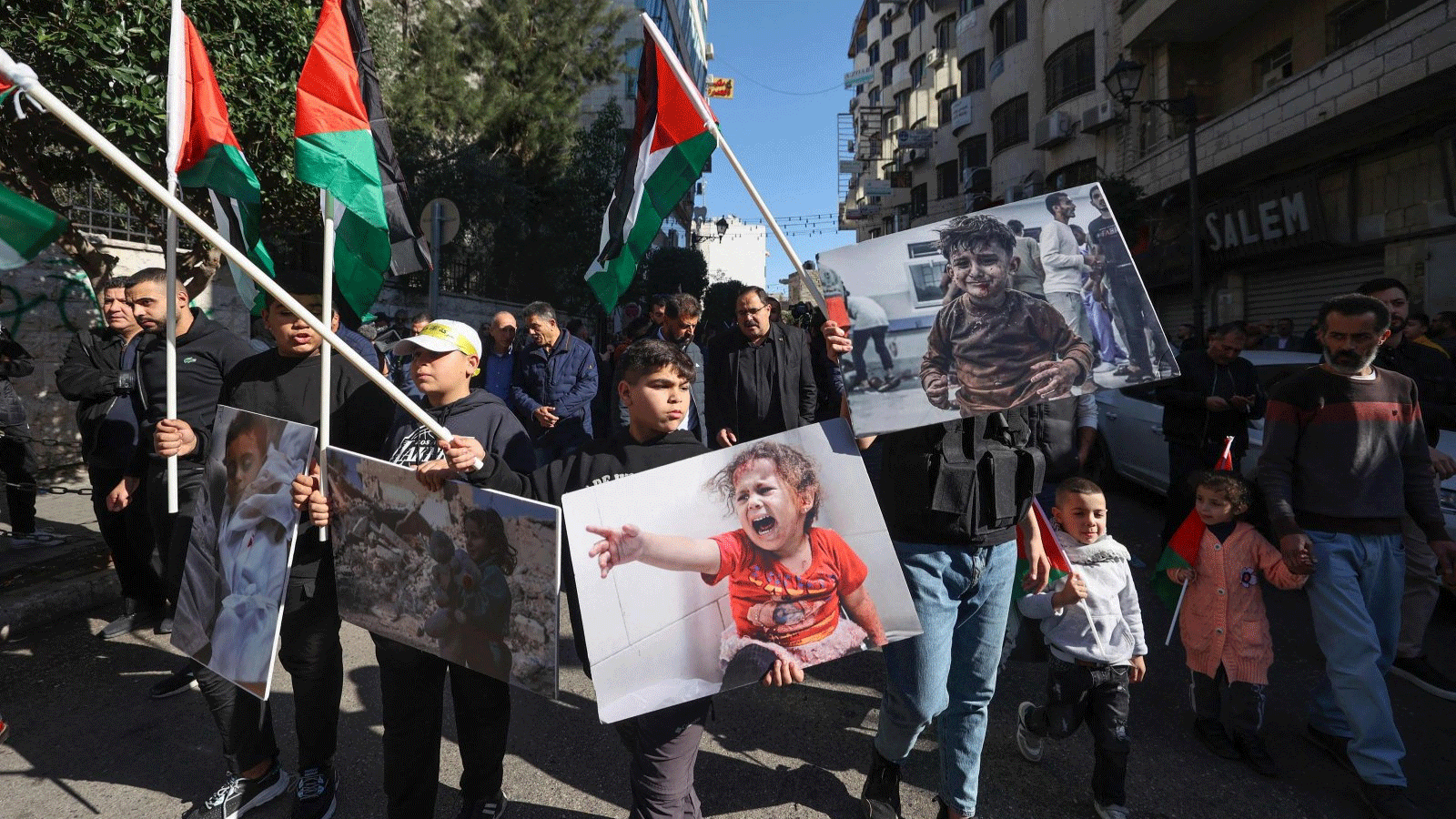 فلسطينيون يرفعون الأعلام الوطنية ويرددون شعارات خلال إضراب عام في رام الله، الضفة الغربية، فلسطين. 11 ديسمبر(كانون الأول) 2023