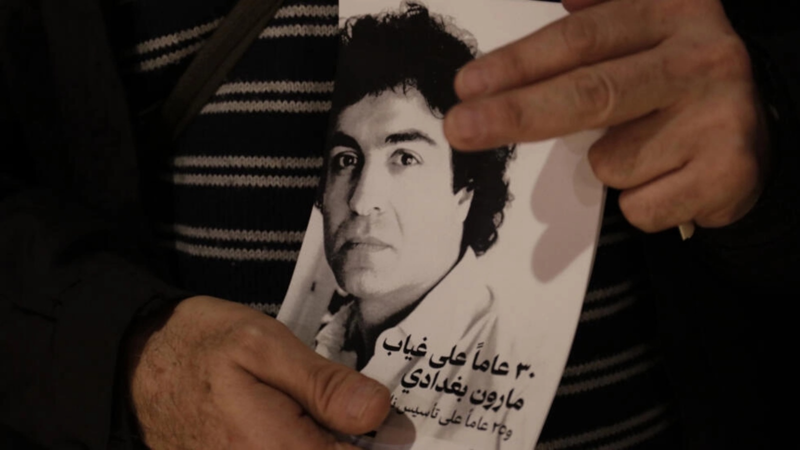 رجل يحمل صورة للمخرج اللبناني الفرنسي الراحل مارون بغدادي في موقع مخصص لأنشطة تقام في بيروت لمناسبة ذكرى مرور ثلاثين عاماً على وفاته، في 12 ديسمبر 2023