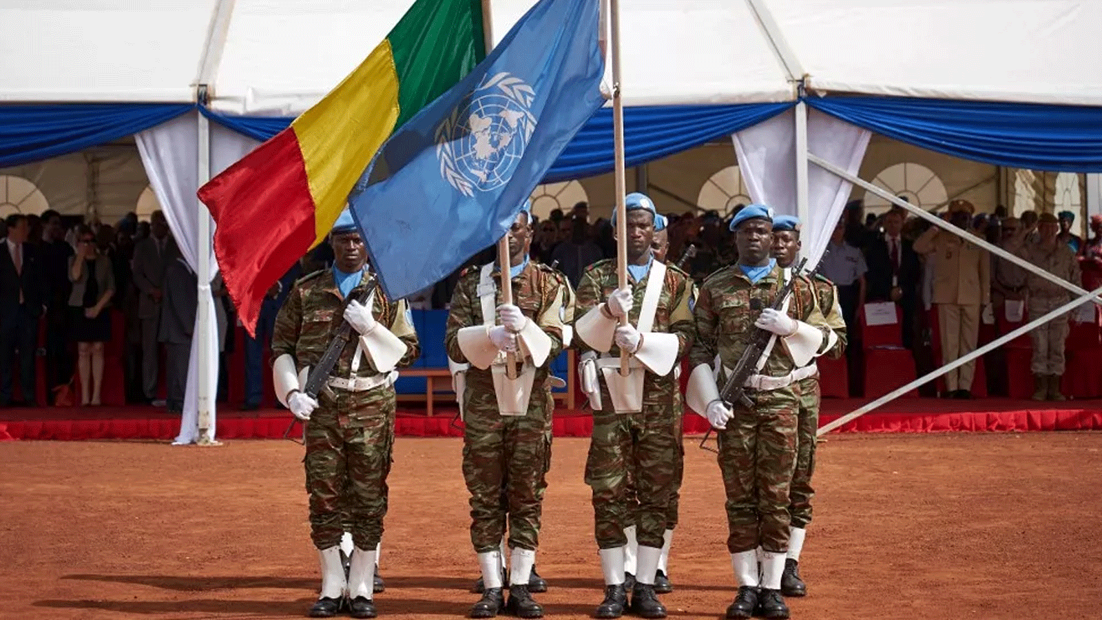 جنود يحملون أعلام الأمم المتحدة ومالي خلال حفل يوم حفظة السلام في مينوسما
