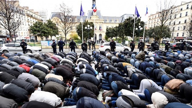 صور أرشيفية لعناصر في الشرطة الفرنسية يراقبون جمعًا من المسلمين يصلي أمام أحد مساجد باريس