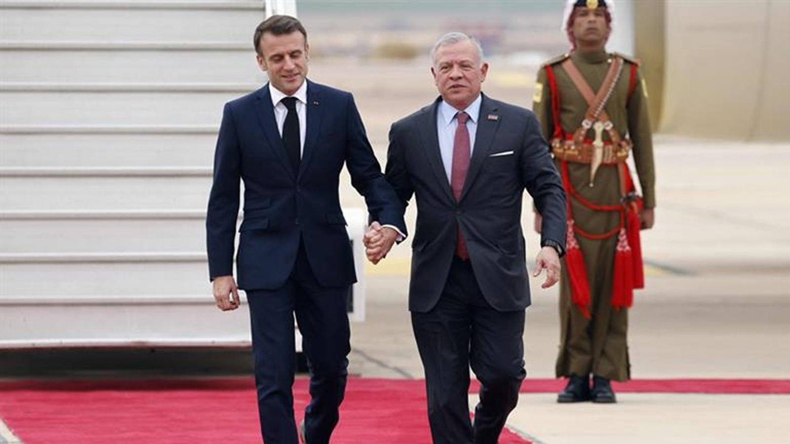 العاهل الأردني الملك عبد الله الثاني مستقبلاً الرئيس الفرنسي إيمانويل ماكرون لدى وصوله إلى مطار العقبة.