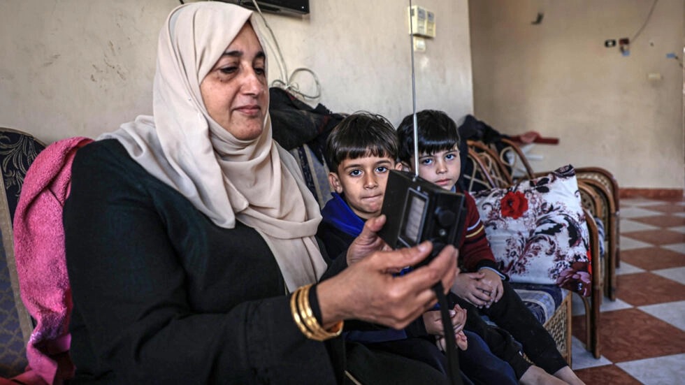 امرأة فلسطينية تستمع إلى الإذاعة عبر جهاز راديو في رفح في جنوب قطاع غزة في 19 كانون الأول/ديسمبر 2023