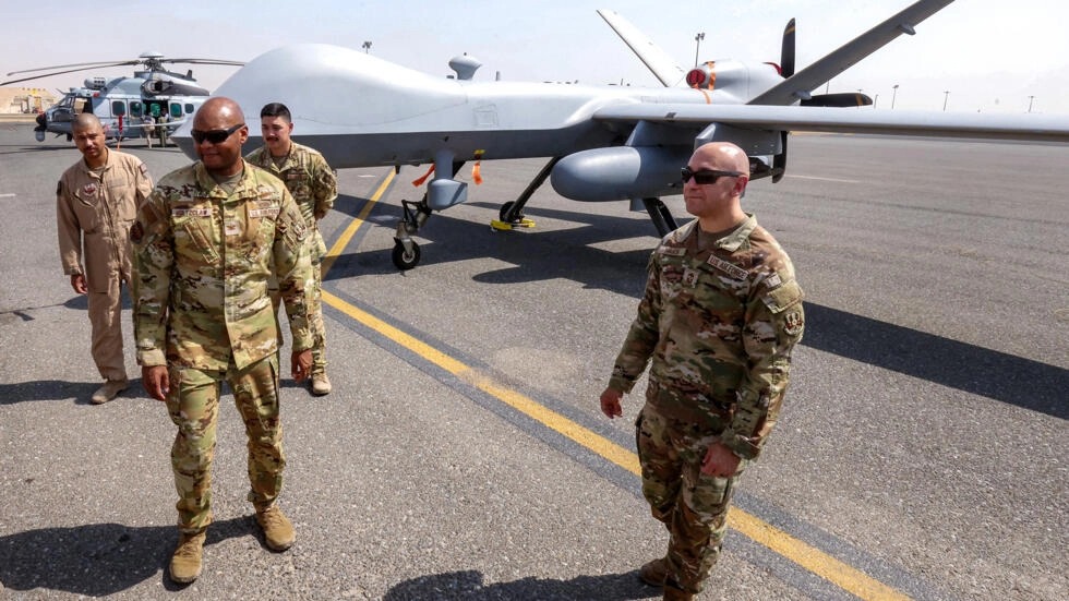 عسكريون أميركيون أمام مسيّرة حربية من طراز إم كيو-9 ريبر في قاعدة علي السالم بالكويت