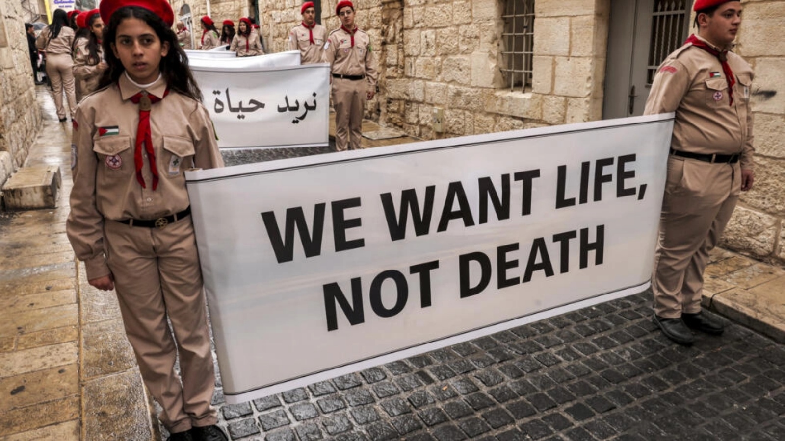 كشافة فلسطينيون يرفعون لافتة كتب عليها 
