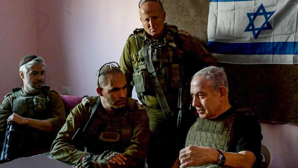 رئيس الوزراء الإسرائيلي بنيامين نتنياهو (على اليمين) يلتقي بجنود في مكان غير معلوم في قطاع غزة في هذه الصورة التي تم التقاطها ونشرها في 26 نوفمبر 2023