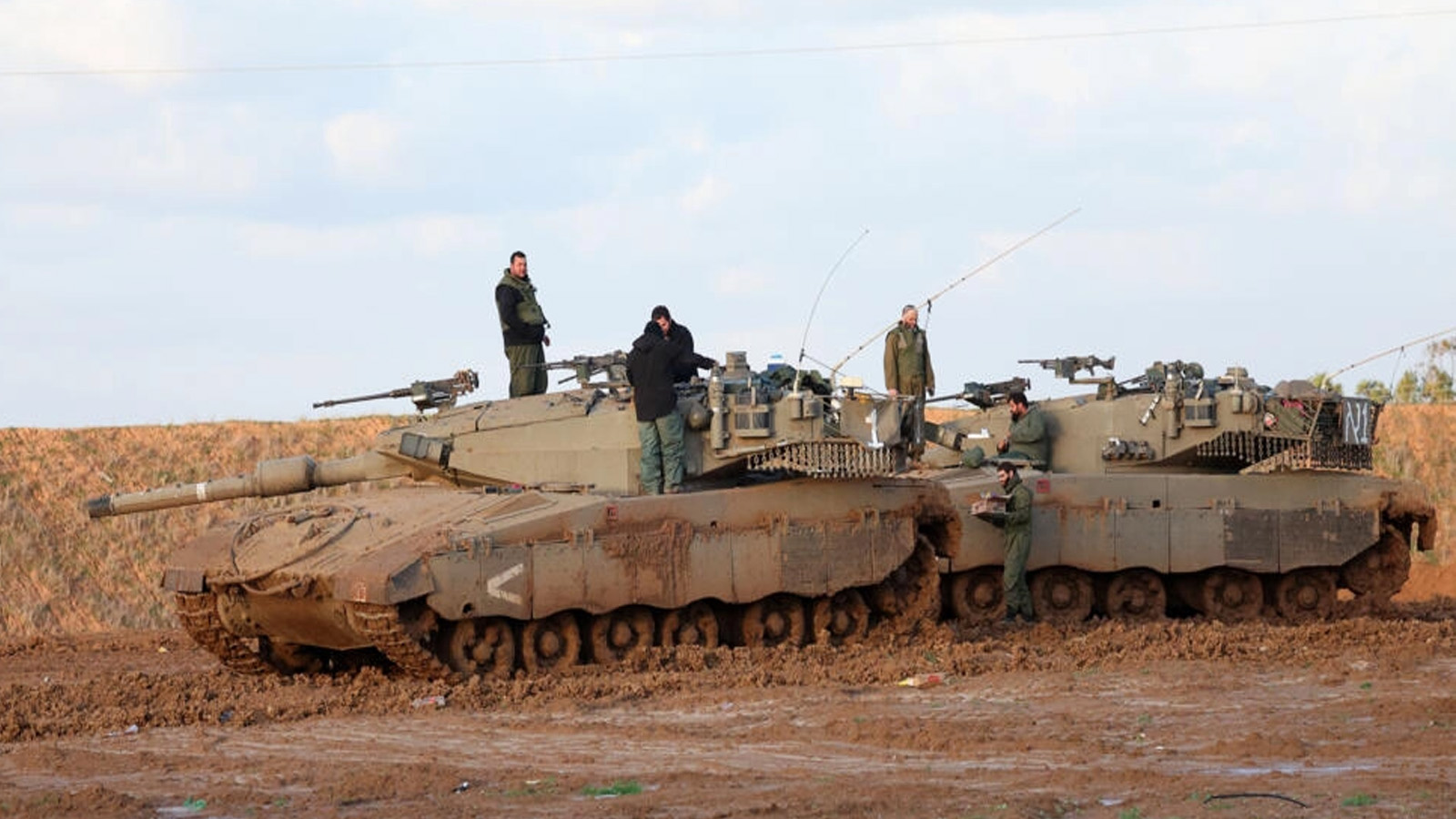 جنود إسرائيليون يقفون على دبابة في موقع في جنوب إسرائيل قرب الحدود مع قطاع غزة مع استمرار القتال بين إسرائيل وحركة حماس، في 12 كانون الثاني(يناير) 2024 