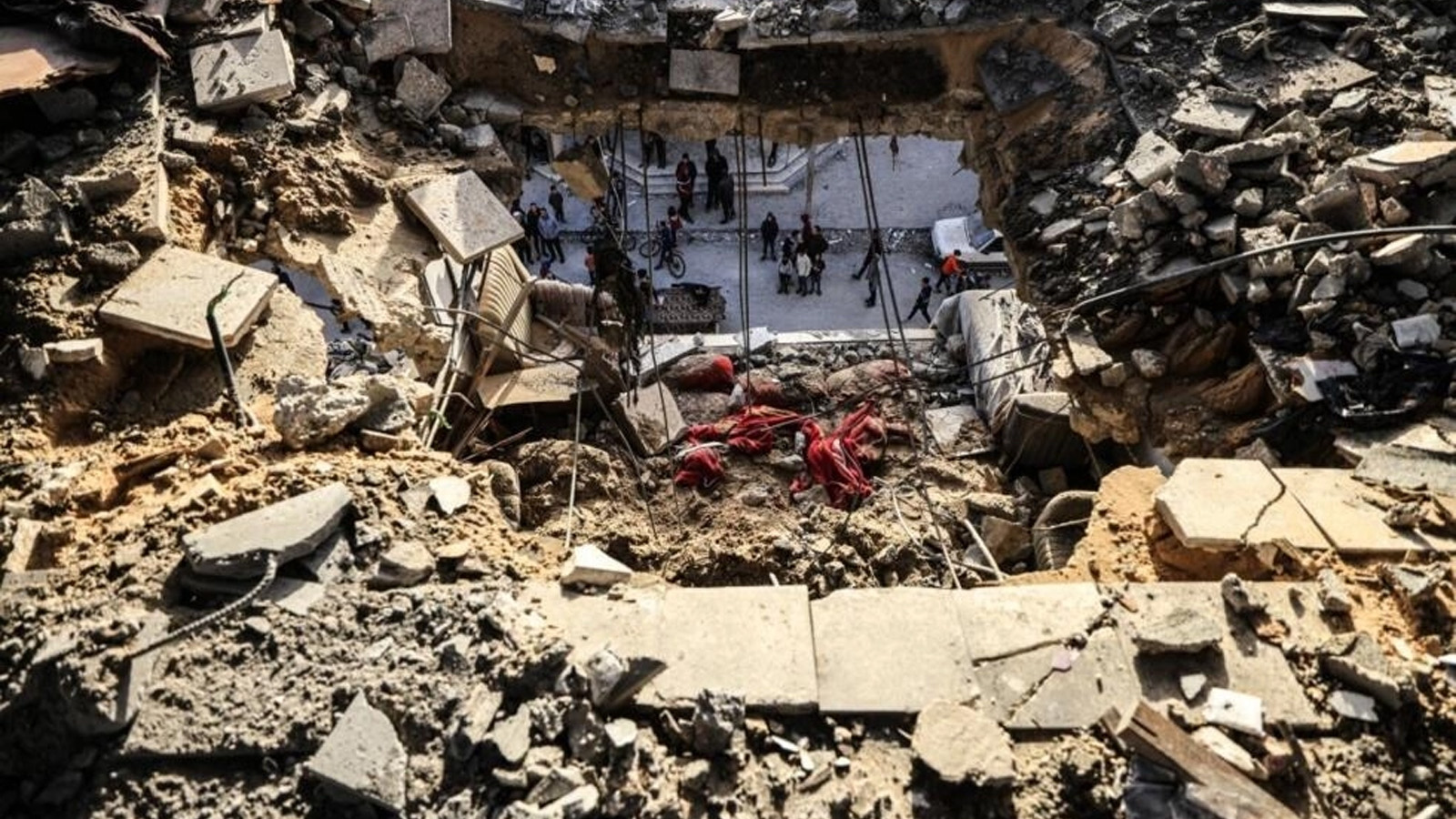 رجال يتفقدون الأضرار التي لحقت بمنزل عائلة نوفل الفلسطينية، الذين قتلوا خلال القصف الإسرائيلي
