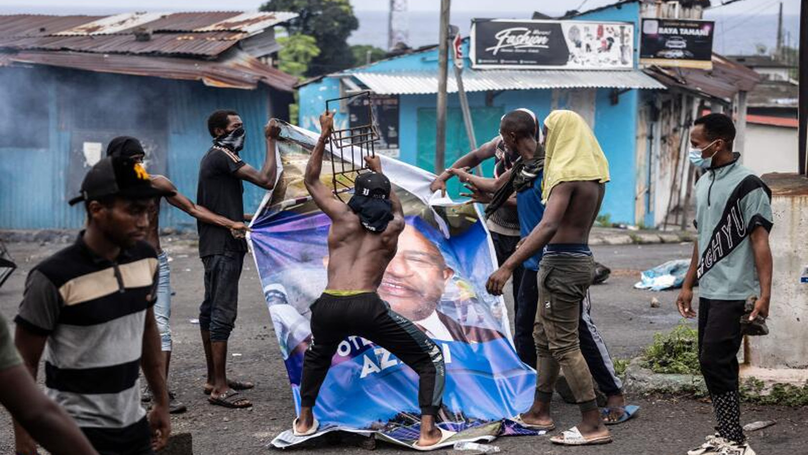 أنصار المعارضة يدمرون صورة لوحة إعلانية لرئيس جزر القمر الحالي غزالي عثماني خلال مظاهرة في موروني في 17 كانون الثاني(يناير) 2024، بعد الإعلان عن الانتخابات الرئاسية