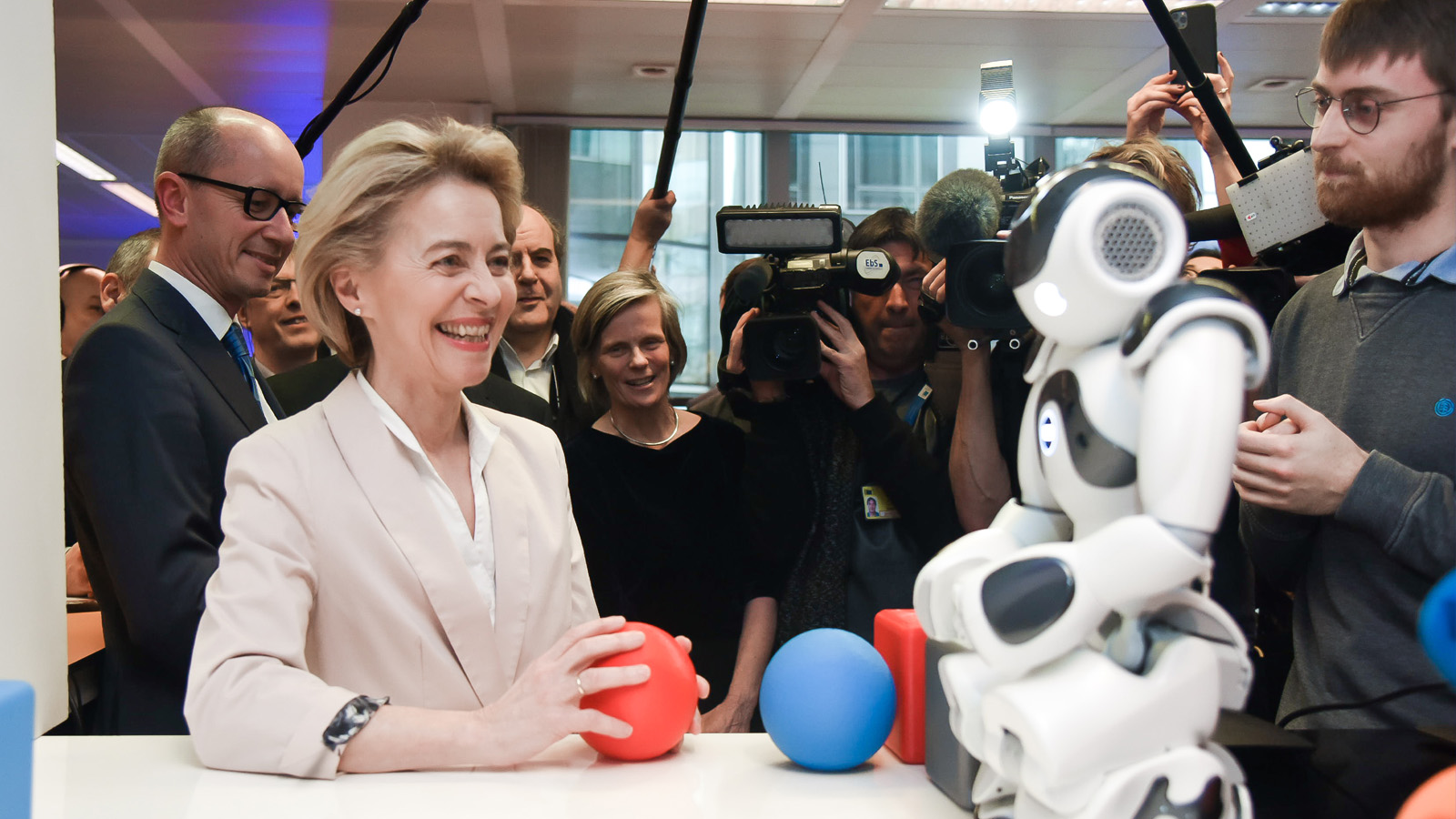 رئيسة المفوضية الأوروبية أورسولا فون دير لايين تقف أمام روبوت في لقطة تفاعلية