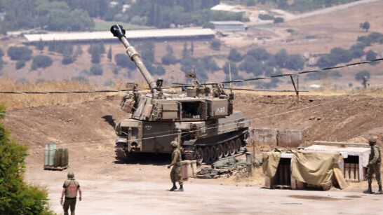 جنود إسرائيليون يقفون بالقرب من مركبة مدفعية ذاتية الدفع تابعة للجيش على مشارف كريات شمونة بالقرب من حدود إسرائيل مع لبنان في 6 يوليو 2023