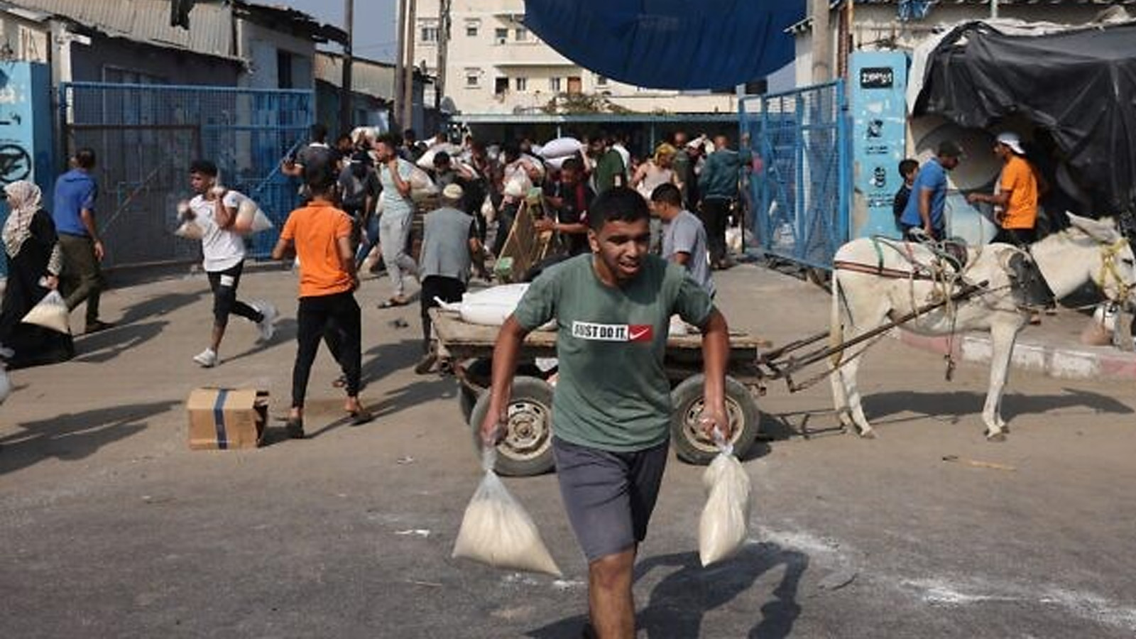 فلسطينيون يقتحمون مركز إمداد المساعدات الذي تديره الأمم المتحدة، والذي يوزع الطعام على العائلات النازحة بعد دعوة إسرائيل لأكثر من مليون ساكن في شمال غزة للانتقال جنوبًا حفاظًا على سلامتهم، في دير البلح