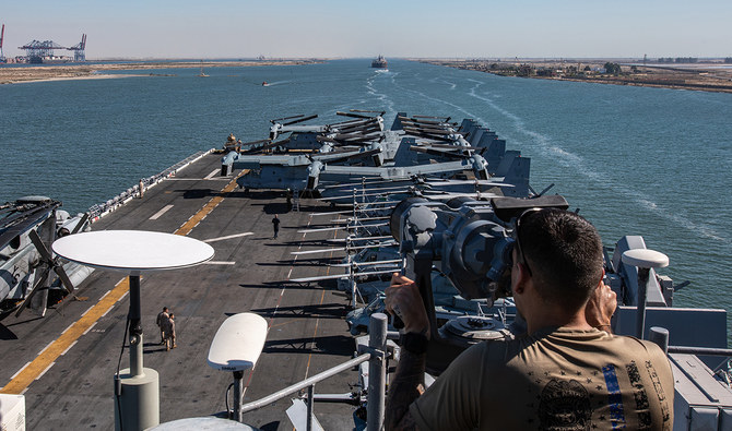 بحار أميركي على متن حاملة الطائرات يو إس إس باتان يراقب عبور السفينة الهجومية البرمائية قناة السويس إلى البحر الأحمر للمساعدة في ضرب الحوثيين في اليمن