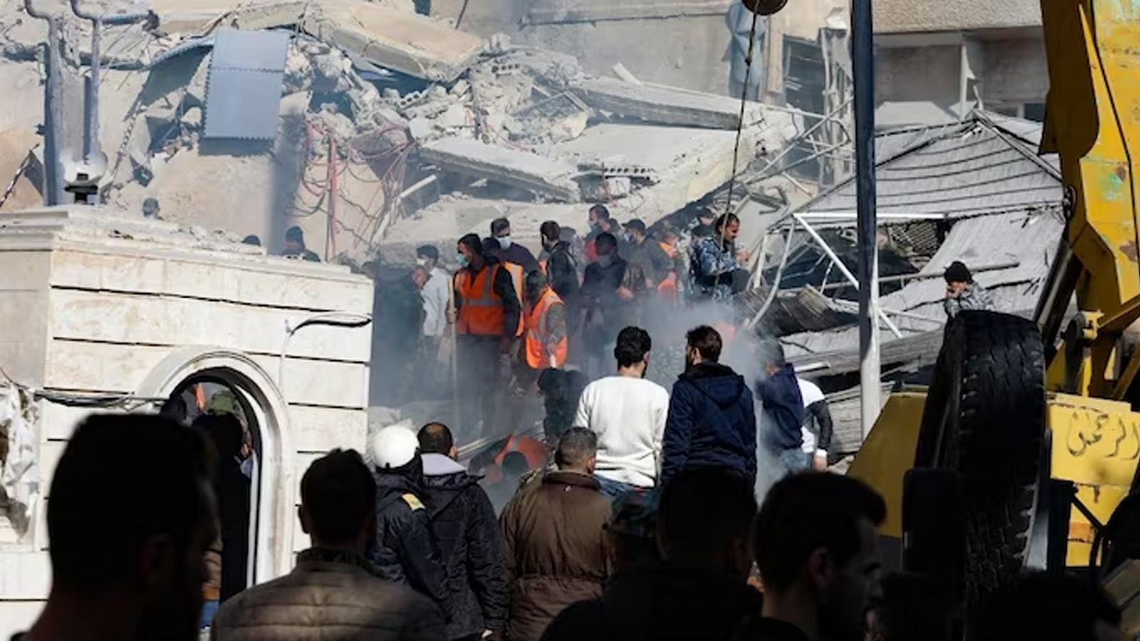 أشخاص وعمال إنقاذ يتجمعون أمام مبنى دمر في غارة إسرائيلية في دمشق