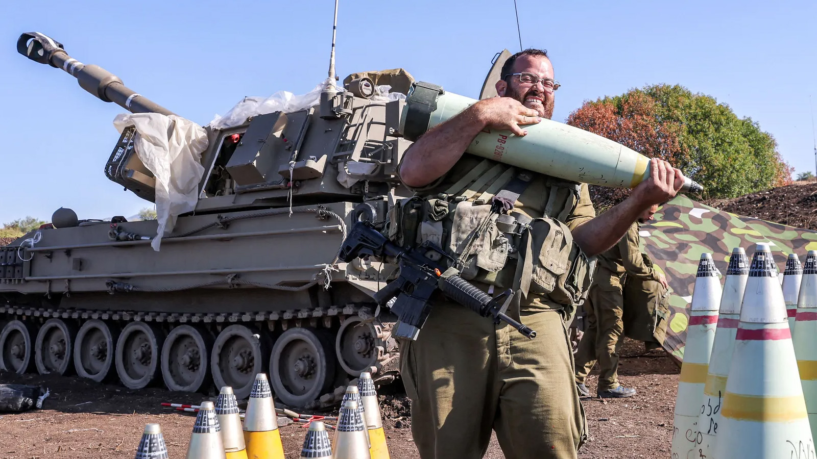 جندي إسرائيلي يحرّك قذيفة مدفعية 155 ملم بالقرب من مدفع هاوتزر ذاتية الدفع بالقرب من الحدود الإسرائيلية اللبنانية، حيث تخوض القوات الإسرائيلية مناوشات مع مقاتلي حزب الله اللبناني