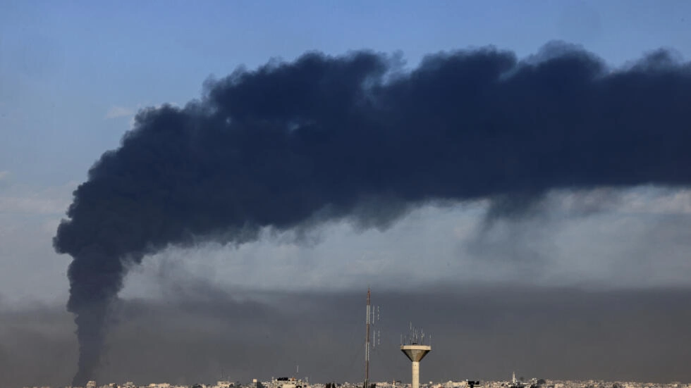 صورة التقطت من رفح تظهر دخانا أسود يتصاعد فوق خان يونس، مركز المعارك في جنوب قطاع غزة، بعد قصف إسرائيلي في 21 كانون الثاني/يناير 2024 