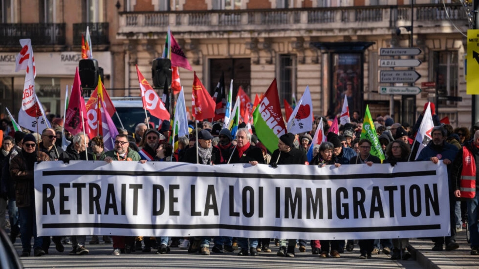 متظاهرون يحملون لافتة تدعو الى سحب قانون الهجرة خلال تظاهرة في تولوز بجنوب فرنسا في 20 كانون الثاني (يناير) 2024.