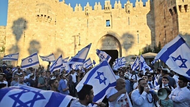 يهود يلوحون بأعلام إسرائيلية أثناء مسيرة خارج باب العامود بالبلدة القديمة في القدس، 15 يونيو، 2021