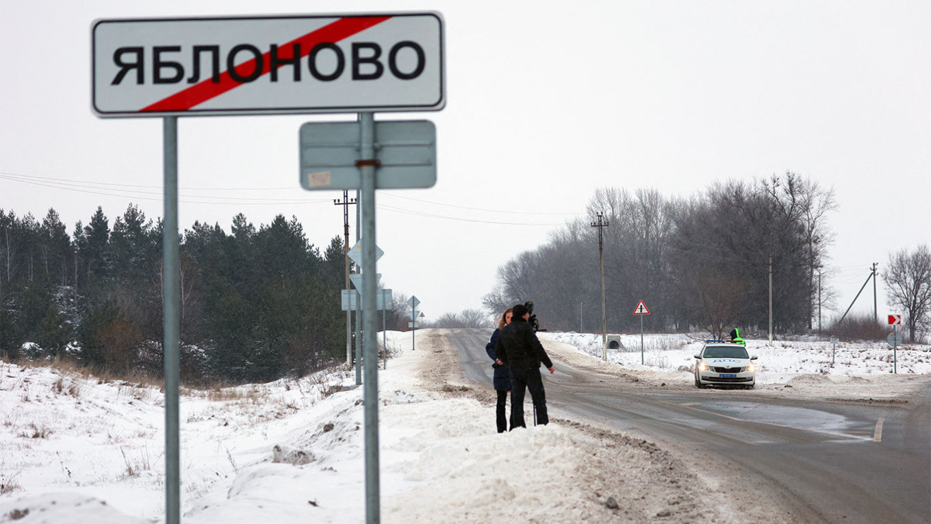 صحفيون يقفون على جانب الطريق خارج قرية يابلونوفو بالقرب من موقع تحطم طائرة النقل العسكرية الروسية من طراز إيل-76