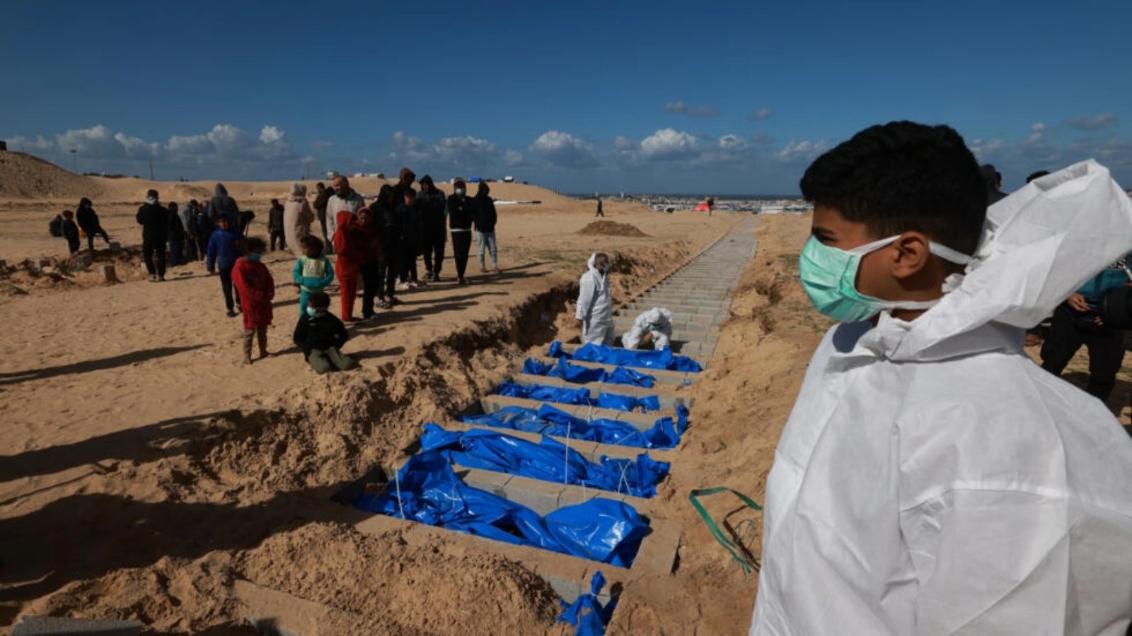 موظفو وزارة الصحة الفلسطينية التابعة لحماس في قطاع غزة يدفنون جثامين أعادتها إسرائيل في قبر جماعي في 30 كانون الثاني (يناير) 2024