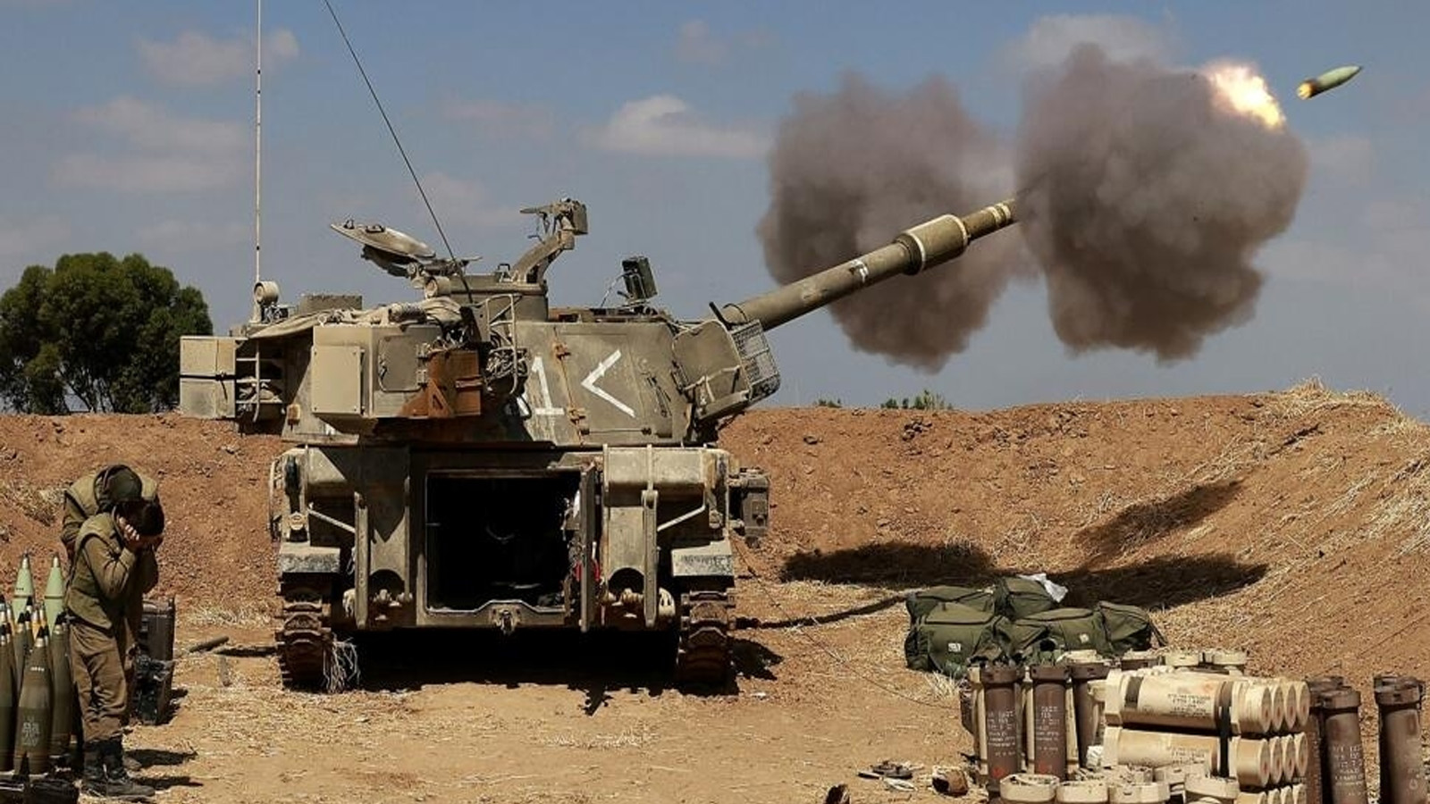 جنود إسرائيليون يطلقون مدفع هاوتزر ذاتي الدفع عيار 155 ملم باتجاه قطاع غزة من موقعهم بالقرب من مدينة سديروت بجنوب إسرائيل في 13 مايو (أيار) 2021