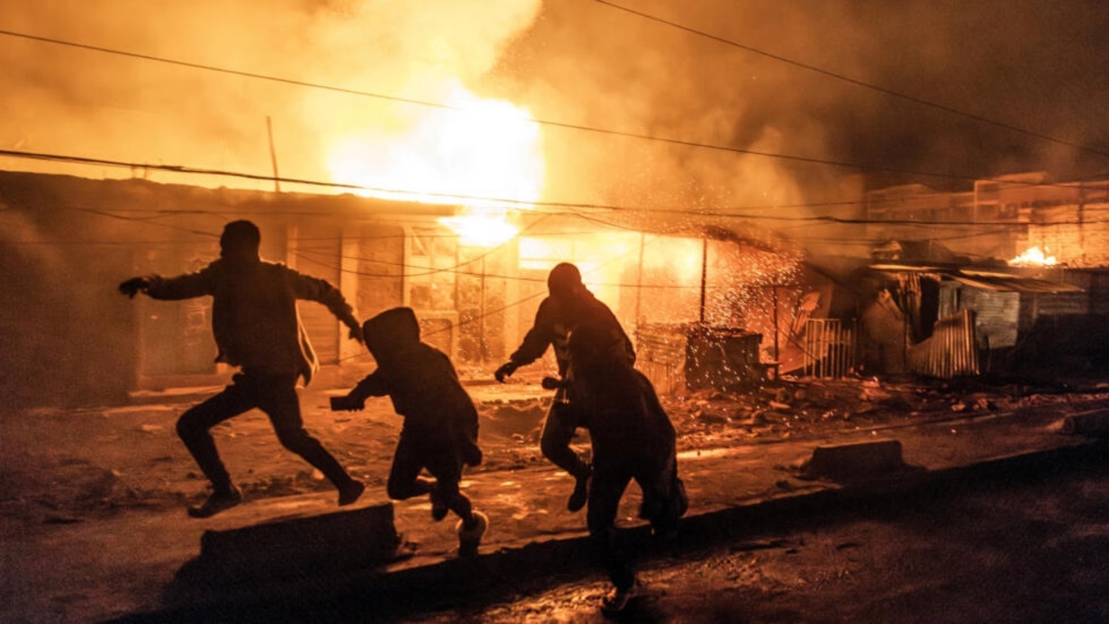 سكان يهربون للاحتماء من حريق اندلع إثر انفجار غاز في منطقة إمباكاسي في العاصمة الكينية نيروبي في 2 شباط (فبراير) 2024 
