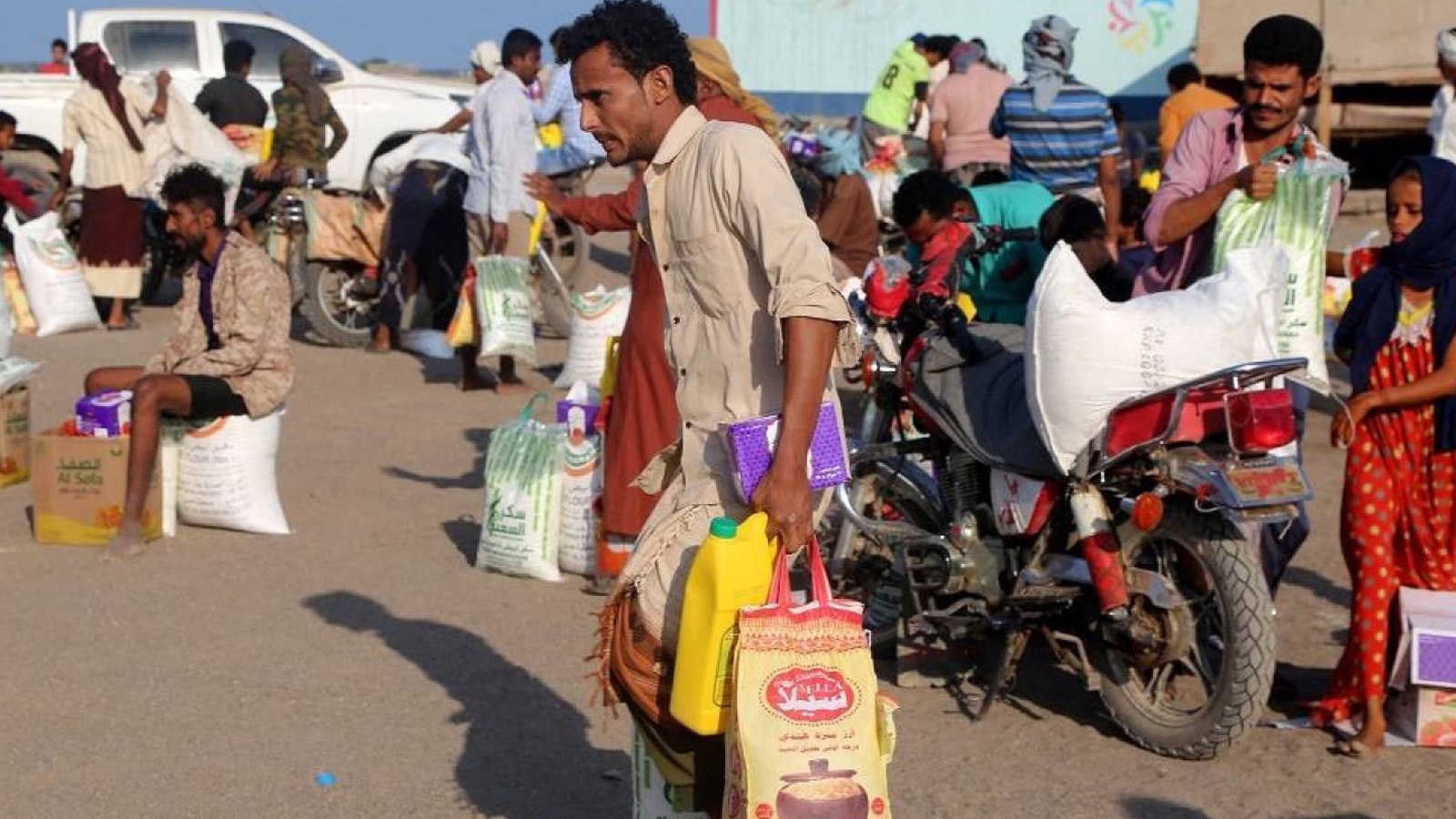 نازحون يمنيون يتلقون أكياس المساعدات الغذائية في مخيم في منطقة حيس بمحافظة الحديدة الغربية التي مزقتها الحرب. في 20 نيسان (أبريل) 2023