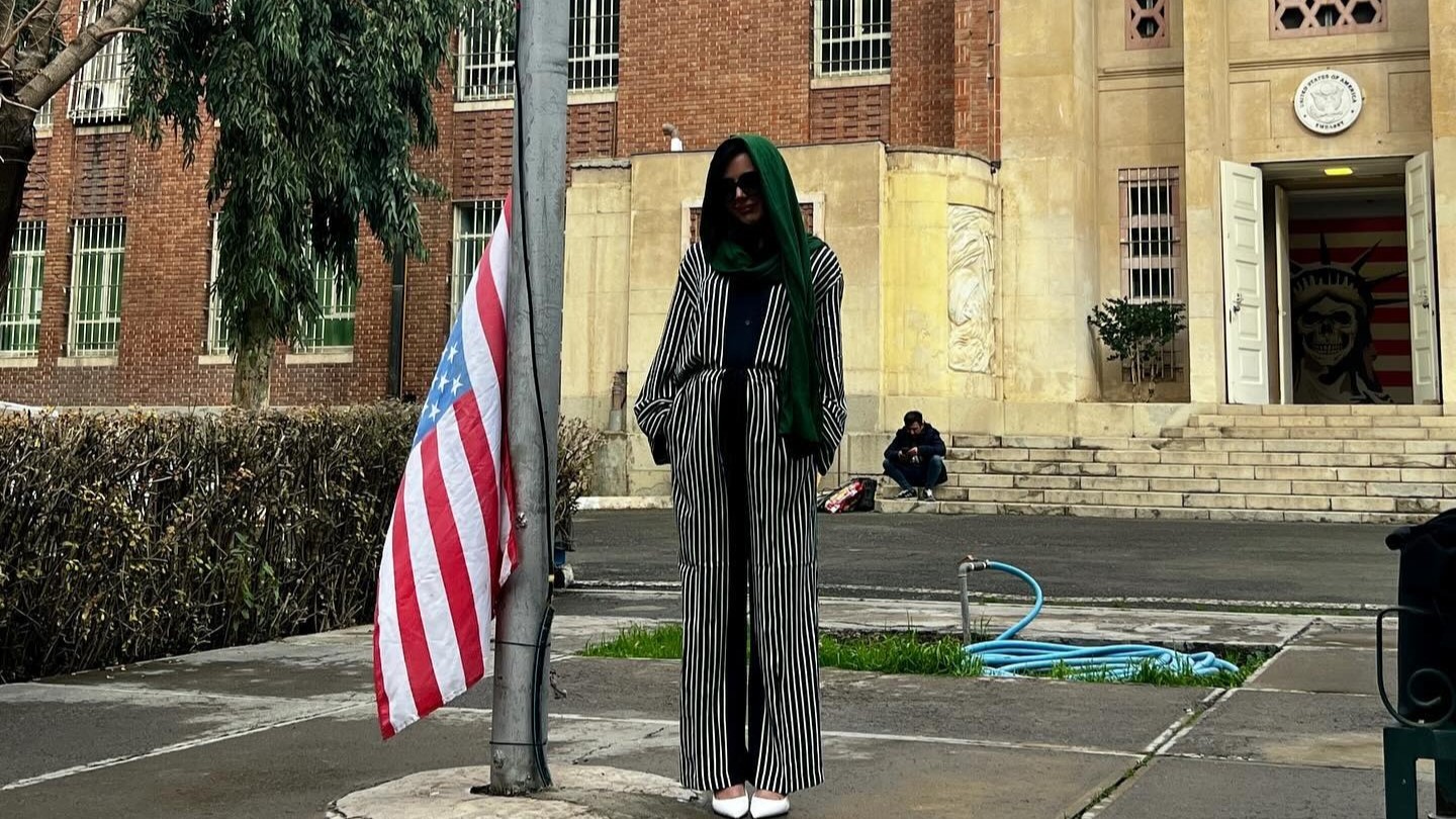 النجمة الإباحية الأميركية ويتني رايت بجانب علم بلادها المنكس أمام السفارة الأميركية السابقة في طهران، في صورة نشرتها هي بنفسها على حسابها في 