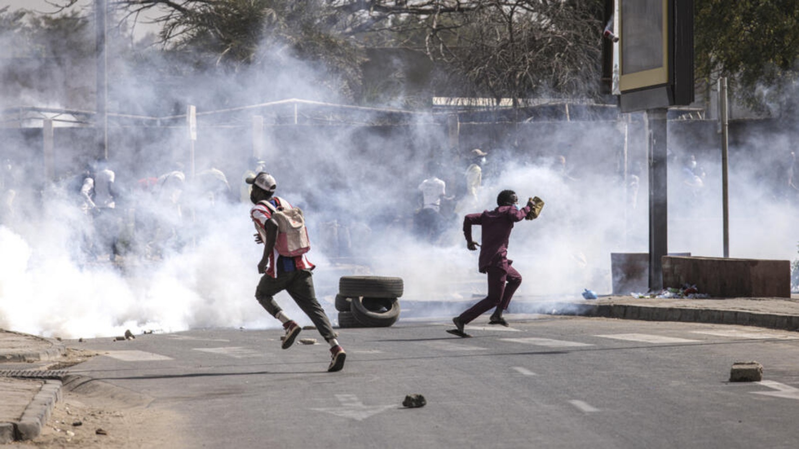 متظاهرون يفرون للاحتماء من الغازات المسيلة للدموع خلال تظاهرة في العاصمة السنغالية دكار في 9 شباط (فبراير) 2024 