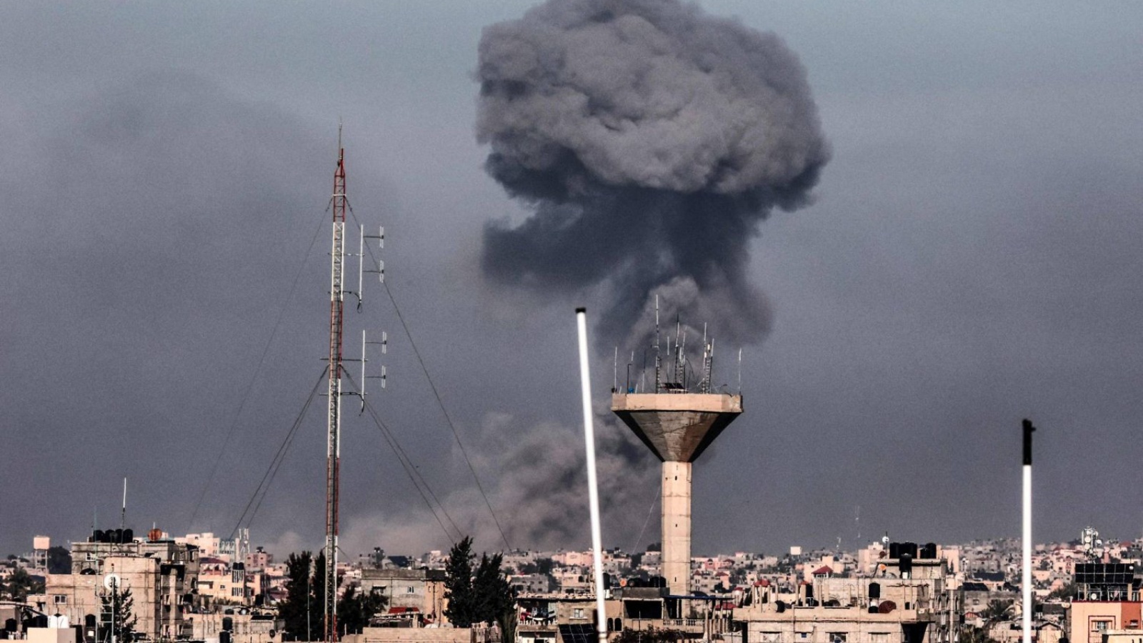 تظهر هذه الصورة الملتقطة من رفح جنوب قطاع غزة الدخان يتصاعد فوق المباني في خان يونس خلال القصف الإسرائيلي في 8 شباط (فبراير) 2024 