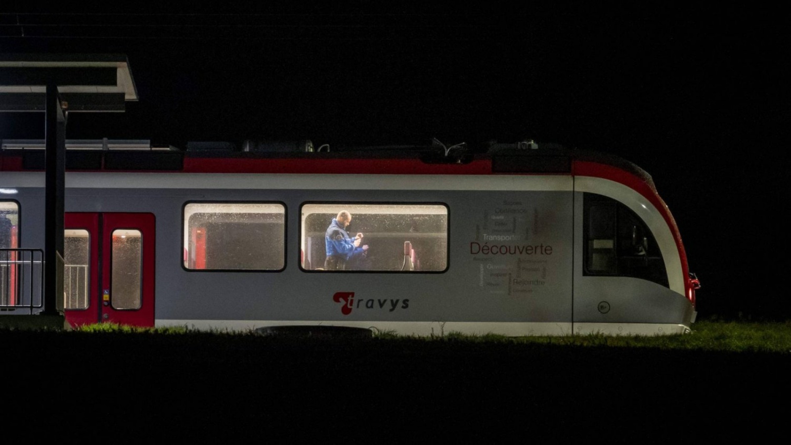 ضابط شرطة سويسري يتفقد الجزء الداخلي من القطار، حيث تم احتجاز الركاب المسافرين من إيفردون إلى سانت كروا كرهائن في وقت سابق، في إسرت-سوس-شامبفينت، غرب سويسرا في 8 شباط (فبراير) 2024