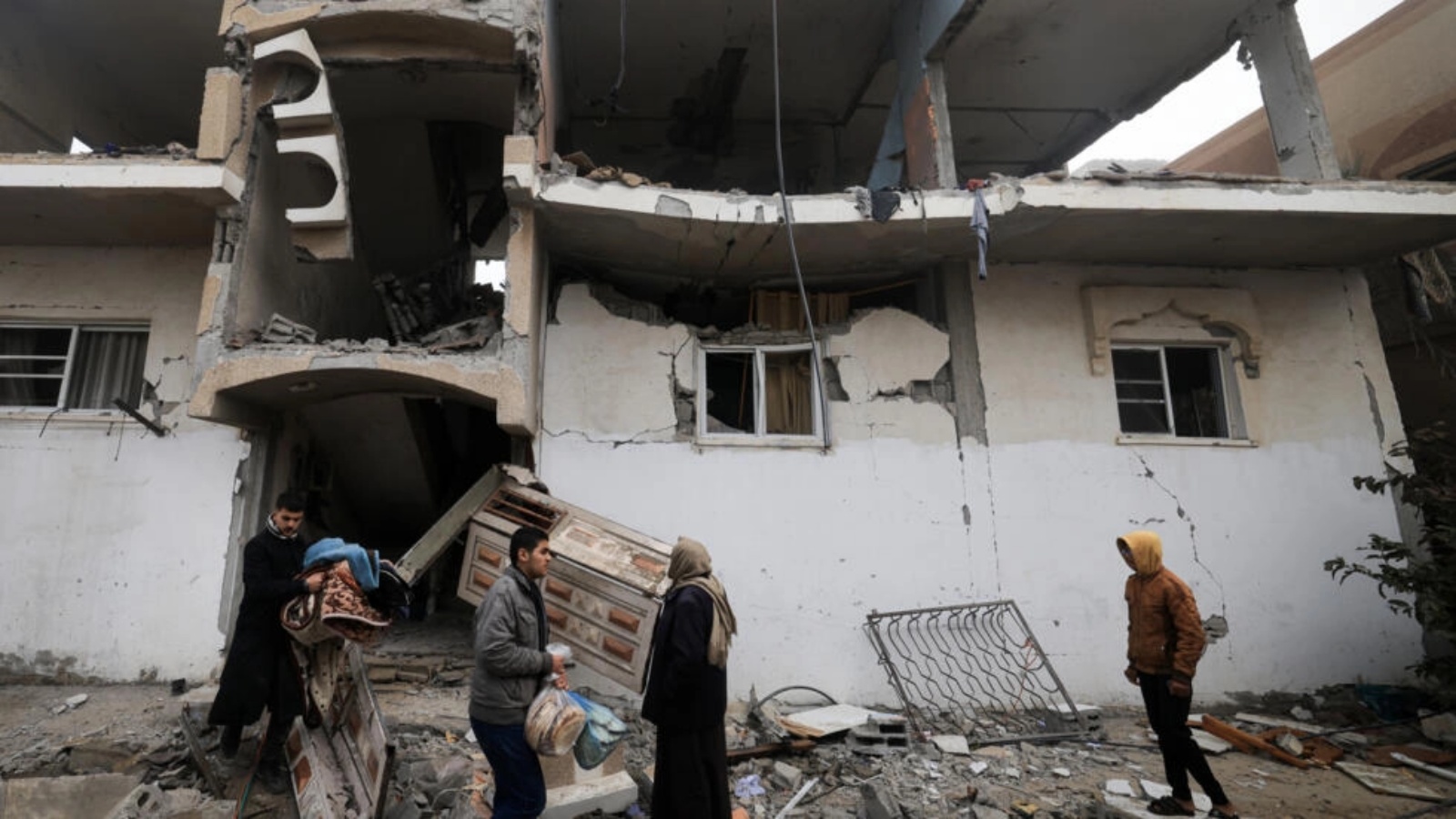 فلسطينيون يجمعون حاجياتهم من مبنى متضرر من القصف الإسرائيلي في مدينة رفح في التاسع من شباط (فبراير) 2024 