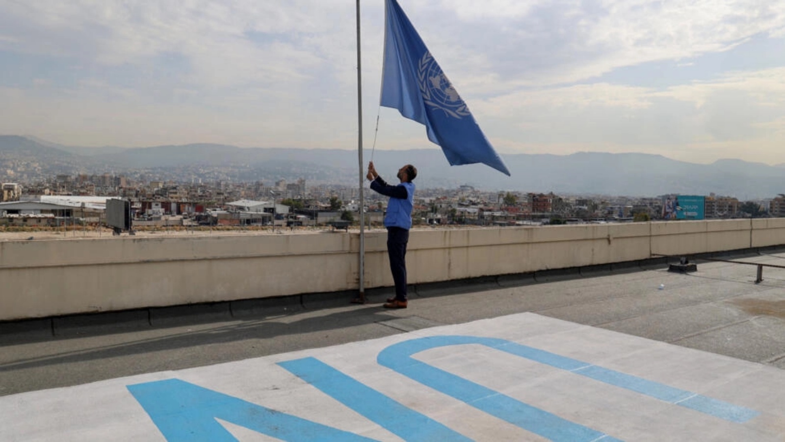موظف في الأونروا ينزل علم الوكالة المرفوع على سطح مقرّها الإقليمي في بيروت في 13 ت2 (نوفمبر) 2023