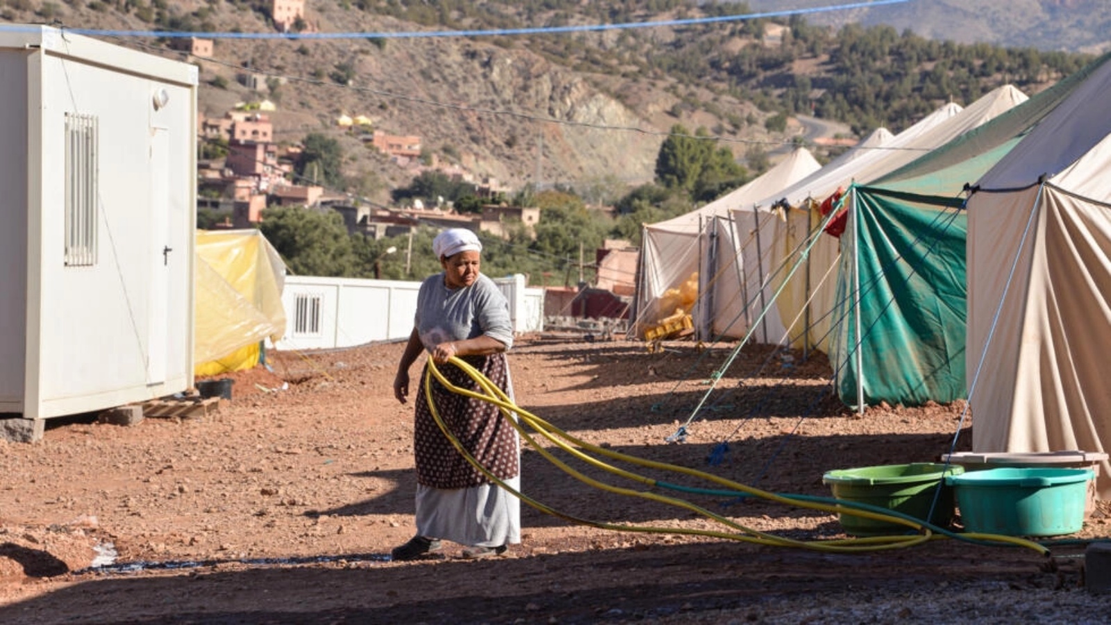 امرأة تستخدم في 27 تشرين الثاني/نوفمبر قسطل مياه في مخيم أقيم في ويرغان على بعد 60 كبلومترا جنوب مراكش في المغرب بعد زلزال الثامن من أيلول (سبتمبر) 2023 