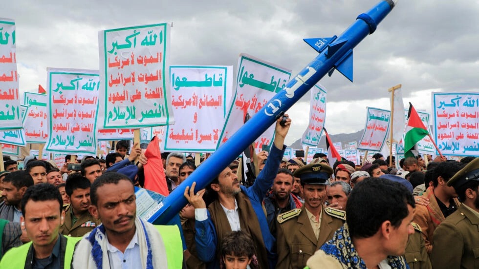 متظاهر يحمل مجسم صاروخ خلال مسيرة في العاصمة صنعاء التي يديرها الحوثيون في 9 فبراير 2024