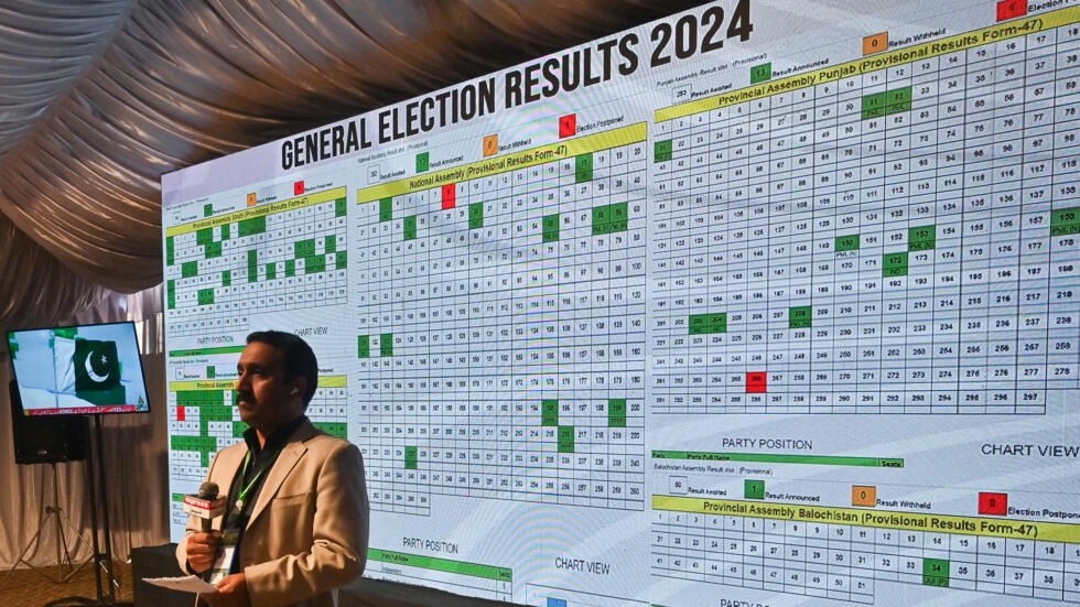 صحافي أمام شاشة يعرض نتائج الانتخابات مباشرة في مكتب لجنة الانتخابات في إسلام آباد، في 9 شباط/فبراير 2024 في باكستان