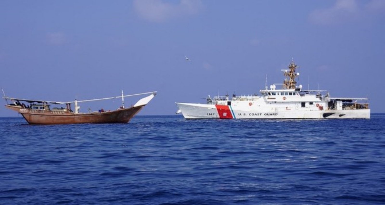 سفينة تابعة للبحرية الأميركية بجوار سفينة يقال إنها تحمل شحنة من الأسلحة الإيرانية كانت متجهة إلى الحوثيين والتي تم الاستيلاء عليها في 28 كانون الثاني (يناير)