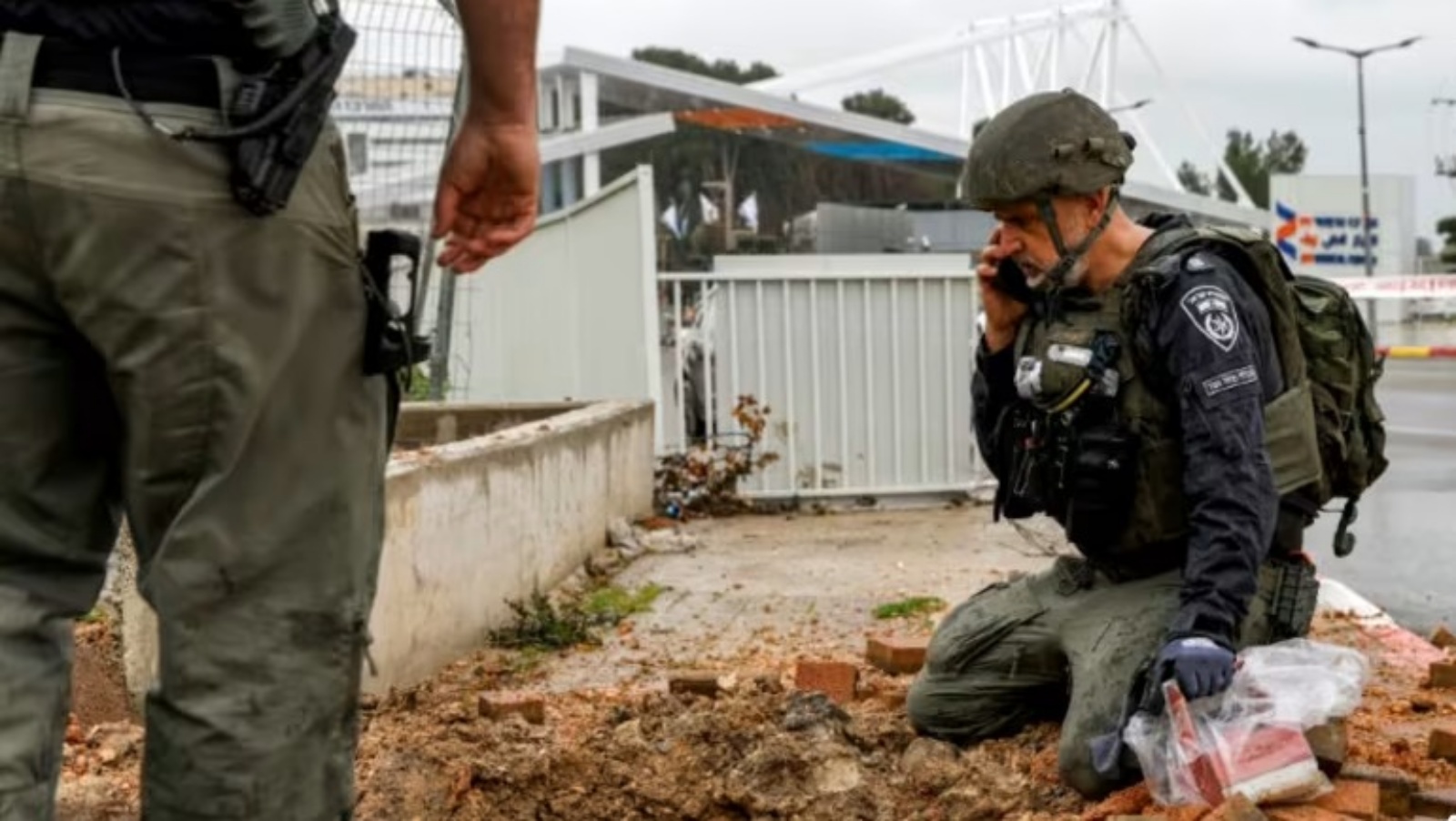 شرطي إسرائيلي يتفحص الحفرة الناجمة عن صاروخ سقط في مدينة صفد الشمالية 15 شباط (فبراير) 2024
