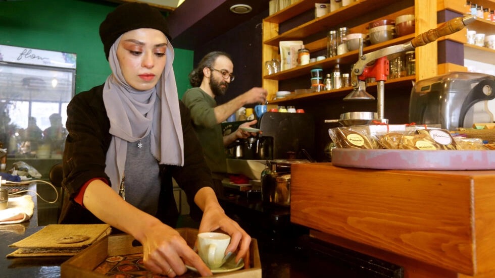 صاحب المقهى إحسان العظمة (يمين) يعد القهوة في دمشق بتاريخ 30 كانون الثاني/يناير 2023