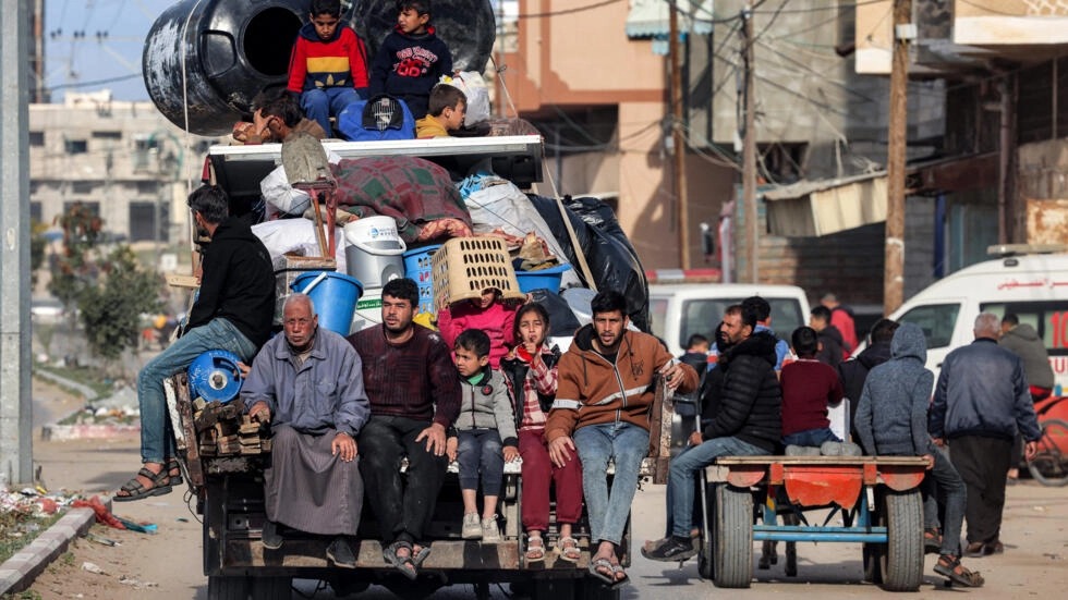 أفراد عائلة فلسطينية في الجزء الخلفي من سيارة محملة بأمتعتهم يغادرون رفح بجنوب قطاع غزة، هرباً من هجوم عسكري إسرائيلي وشيك على المدينة، في 12 شباط/فبراير 2024