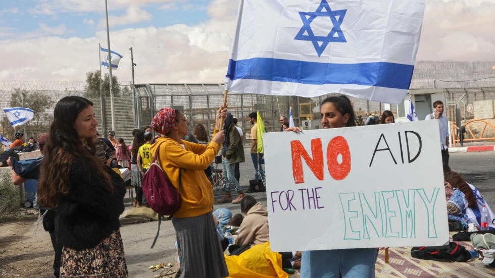 متظاهرون إسرائيليون على الحدود مع مصر عند نقطة نيتسانا بجنوب اسرائيل في 18 شباط/فبراير اثناء محاولتهم منع شاحنات المساعدات من دخول غزة