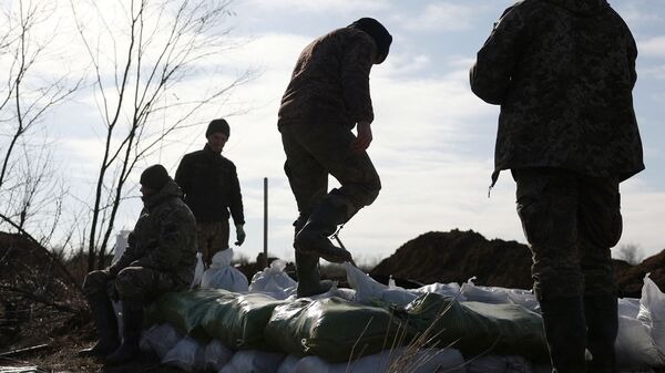 جنود أوكرانيون يجمعون الأكياس الترابية لبناء حصن ليس بعيدًا عن بلدة أفدييفكا في منطقة دونيتسك، وسط الغزو الروسي لأوكرانيا، في 17 فبراير